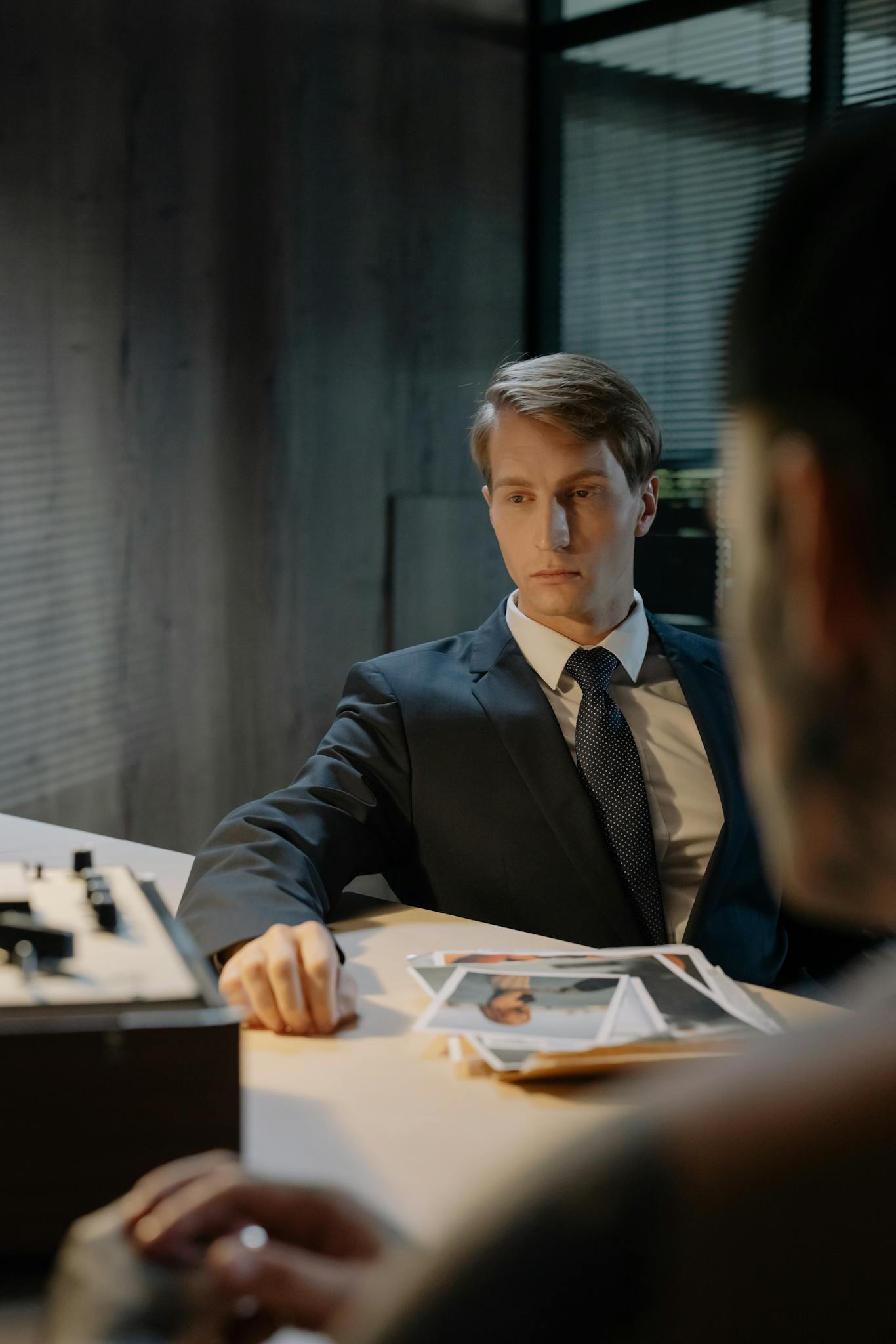 A tense interrogation scene with a detective and suspect in a dimly lit room.
